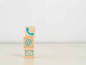 Wooden cubes with symbol telephone, email and address.