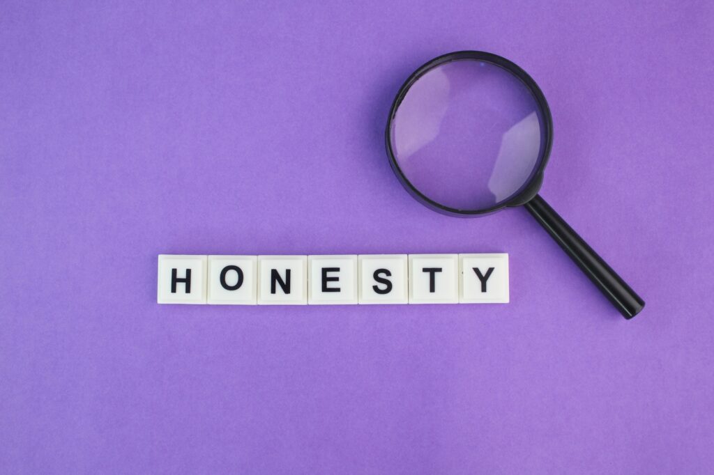 magnifying glass with alphabet letters of the word honesty. the concept of one's honesty.