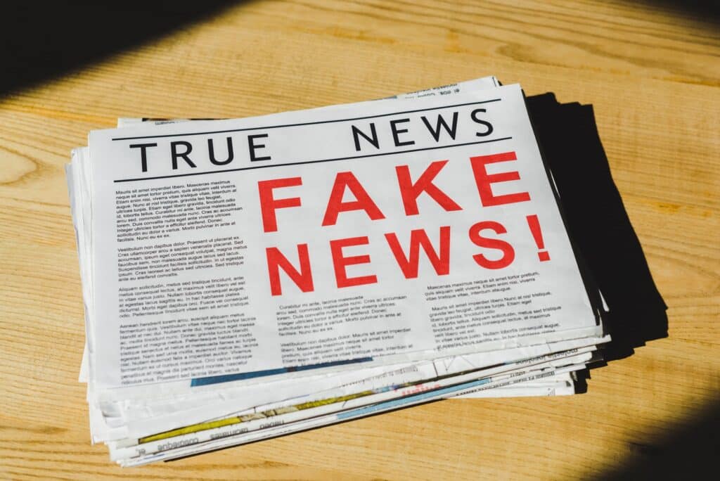 pile of newspapers with fake and true news on wooden table